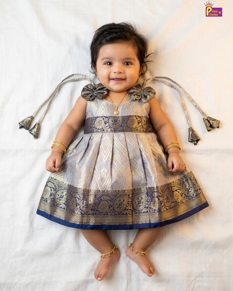 Baby wearing a traditional outfit with decorative elements on a white background