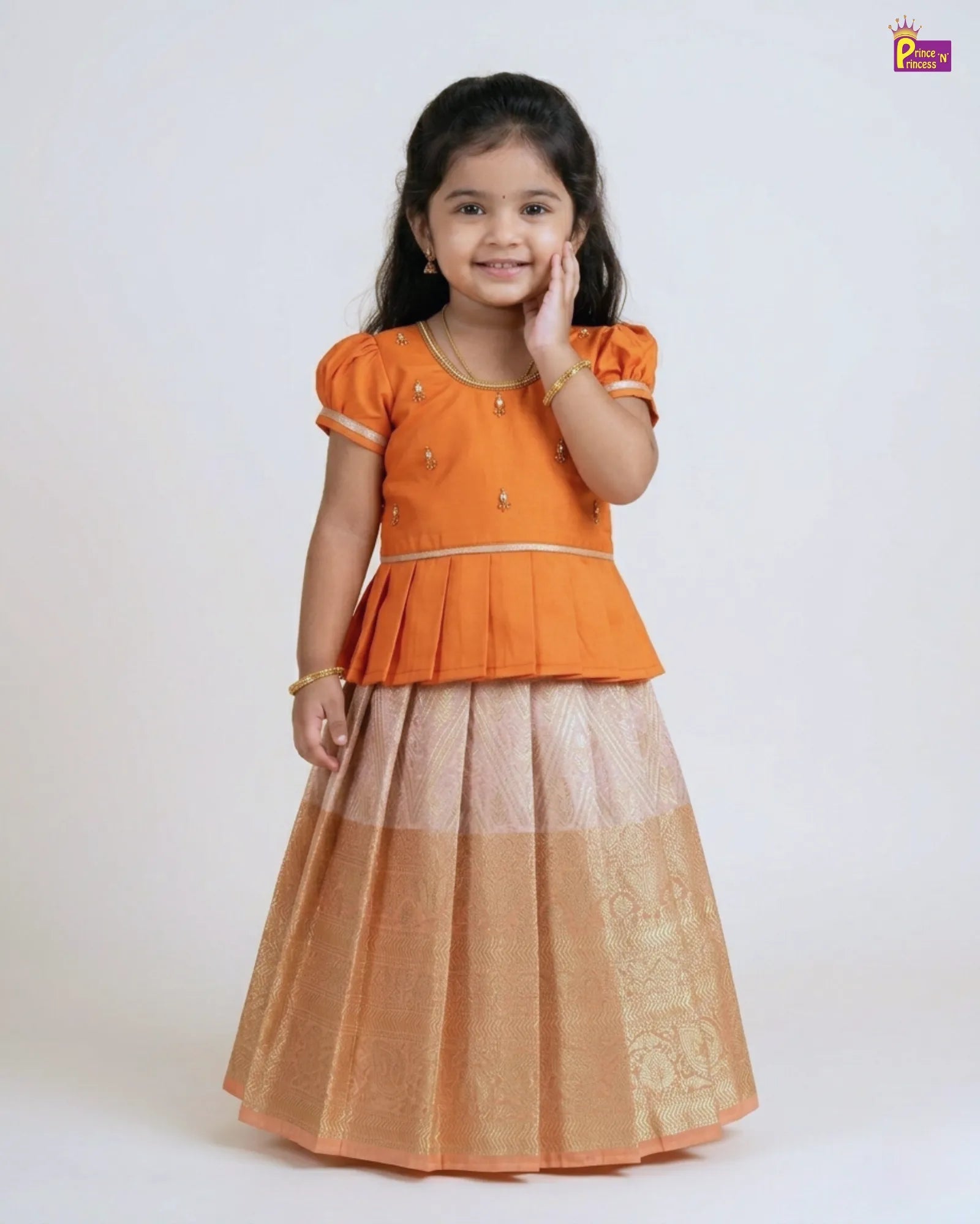 Young girl wearing an orange top and brown skirt on a white background