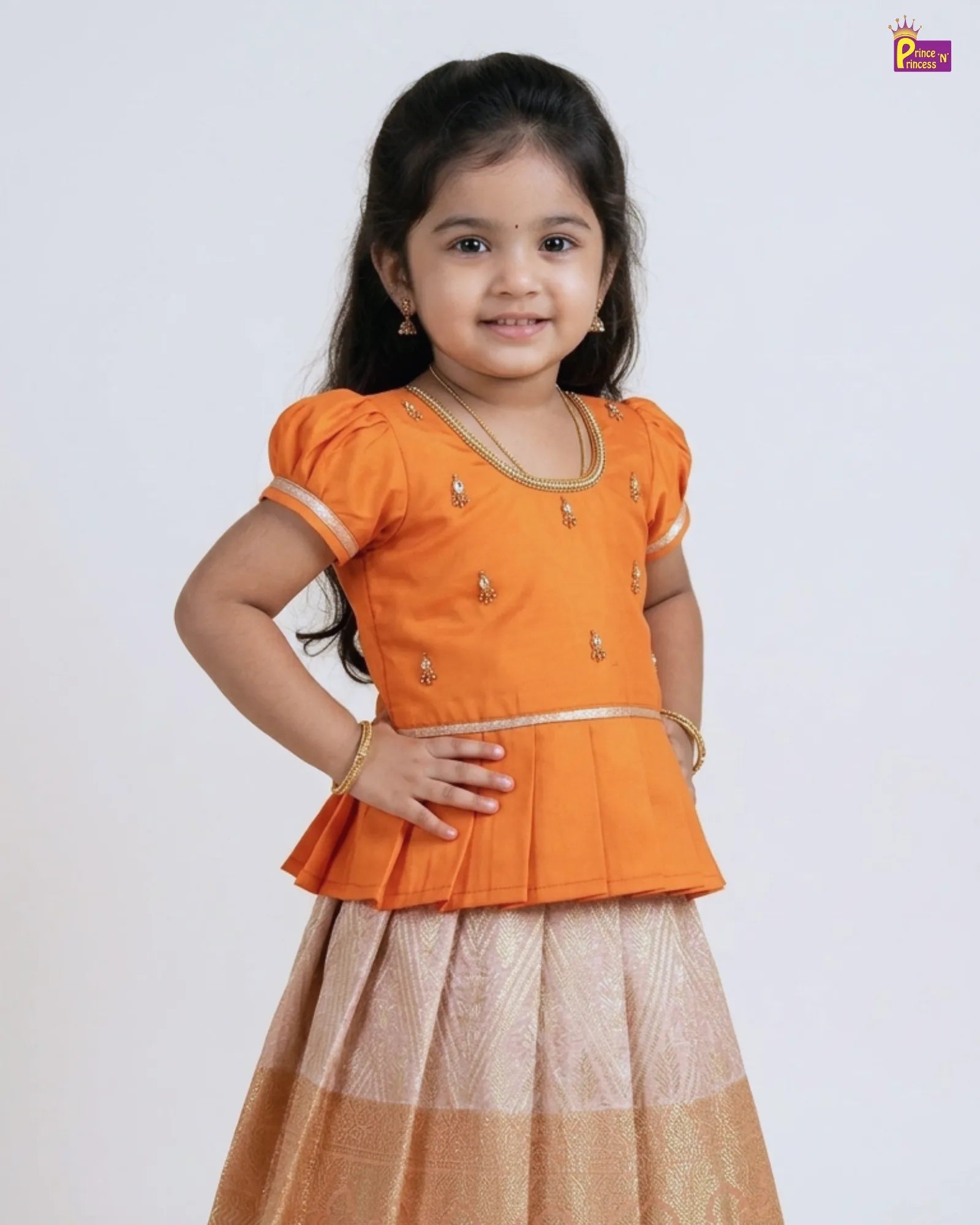 Young girl wearing an orange top and beige skirt on a white background