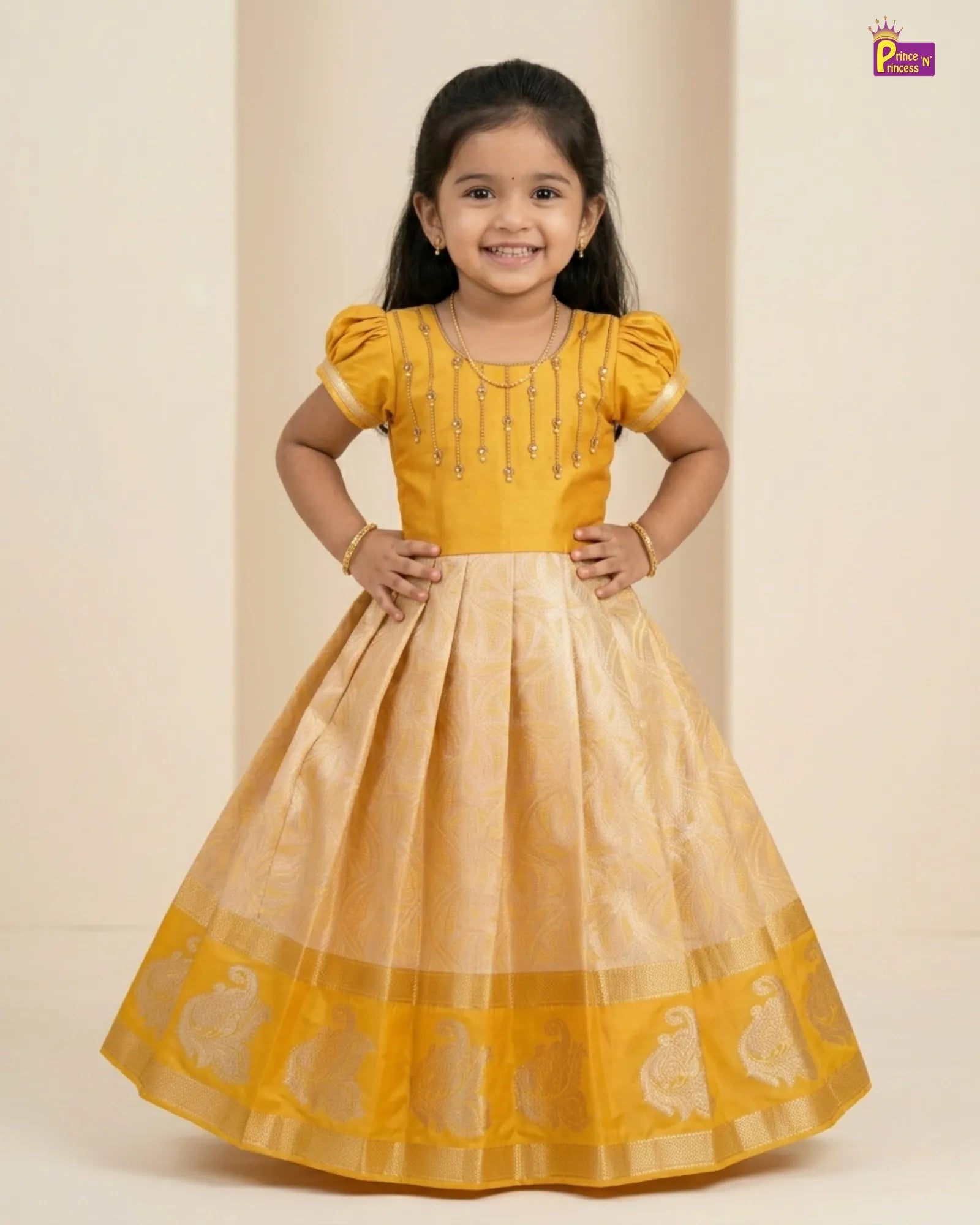 Young girl wearing a yellow and beige traditional dress on a plain background