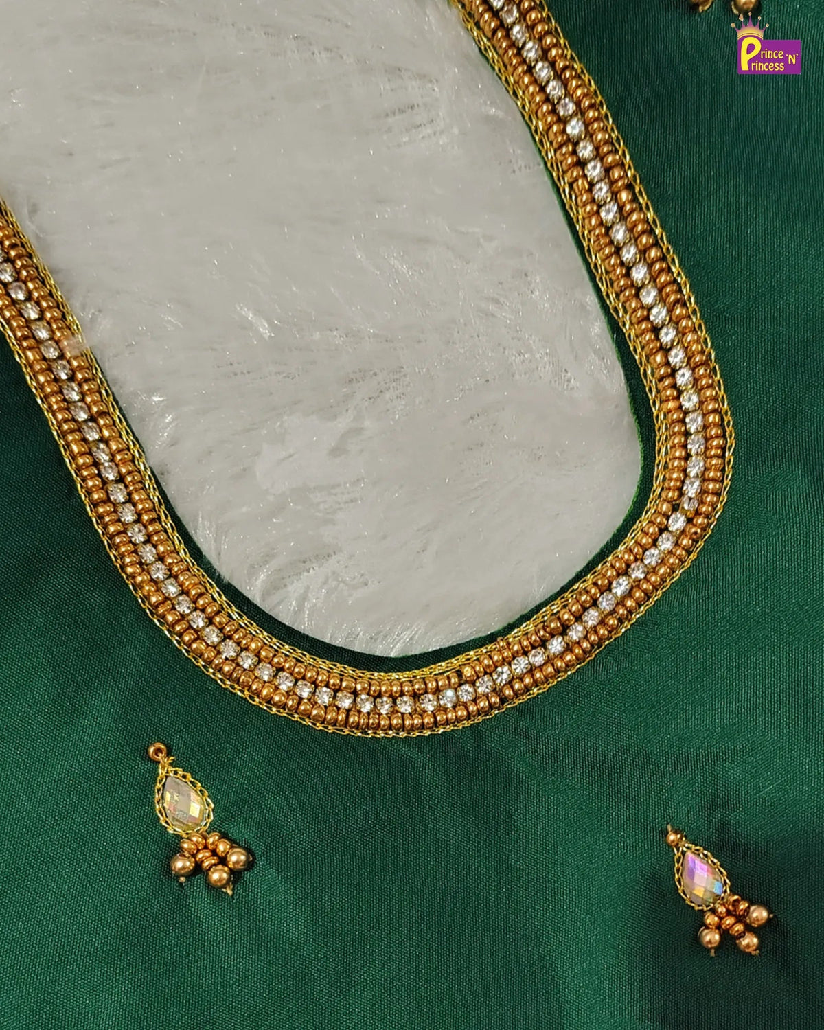 Gold beaded neckline trim with embedded clear stones, displayed on a green fabric background with matching gold and purple jhumka earrings.