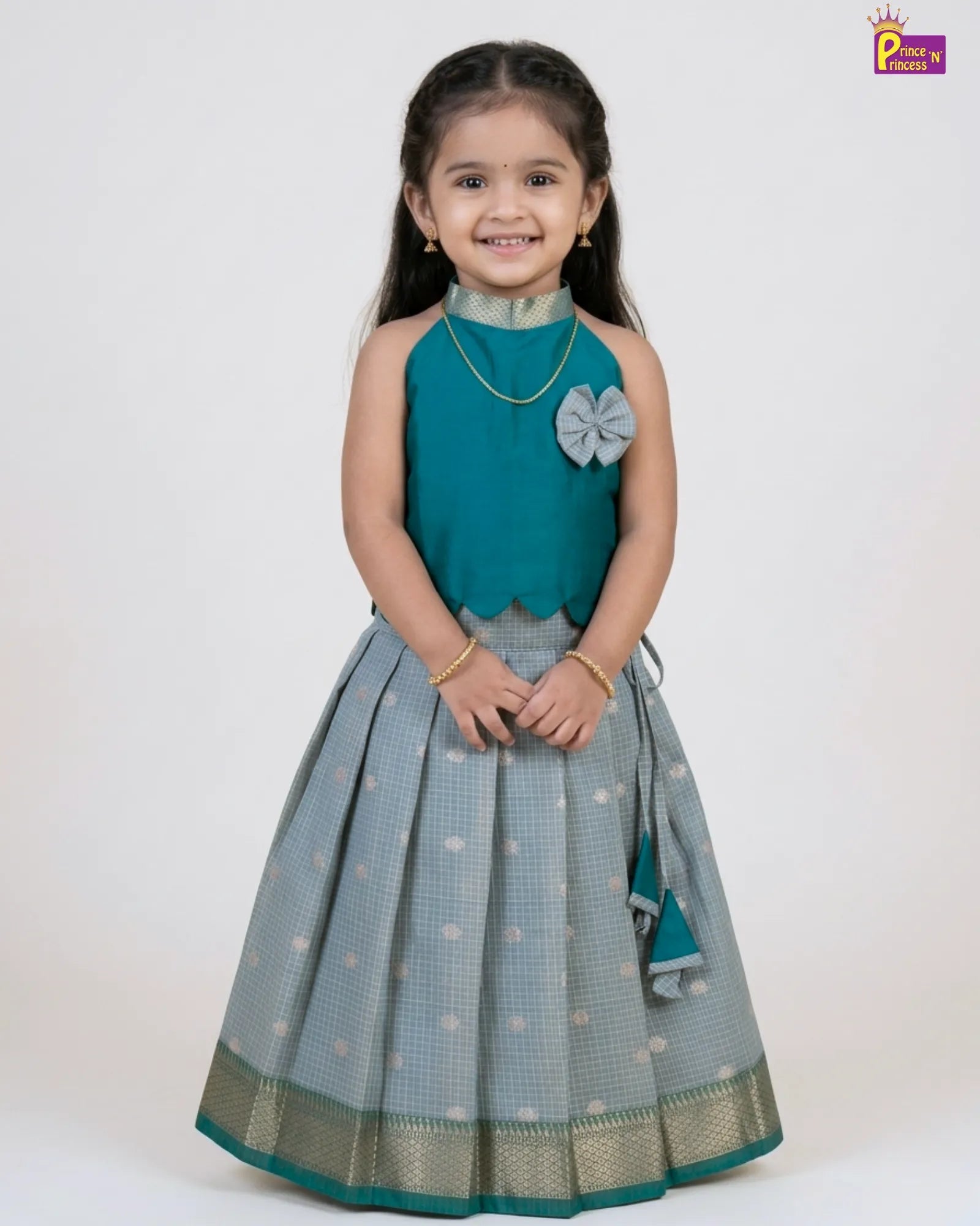 Girl wearing Rama green raw silk Pattu Pavadai with silver skirt and gold border traditional kids dress