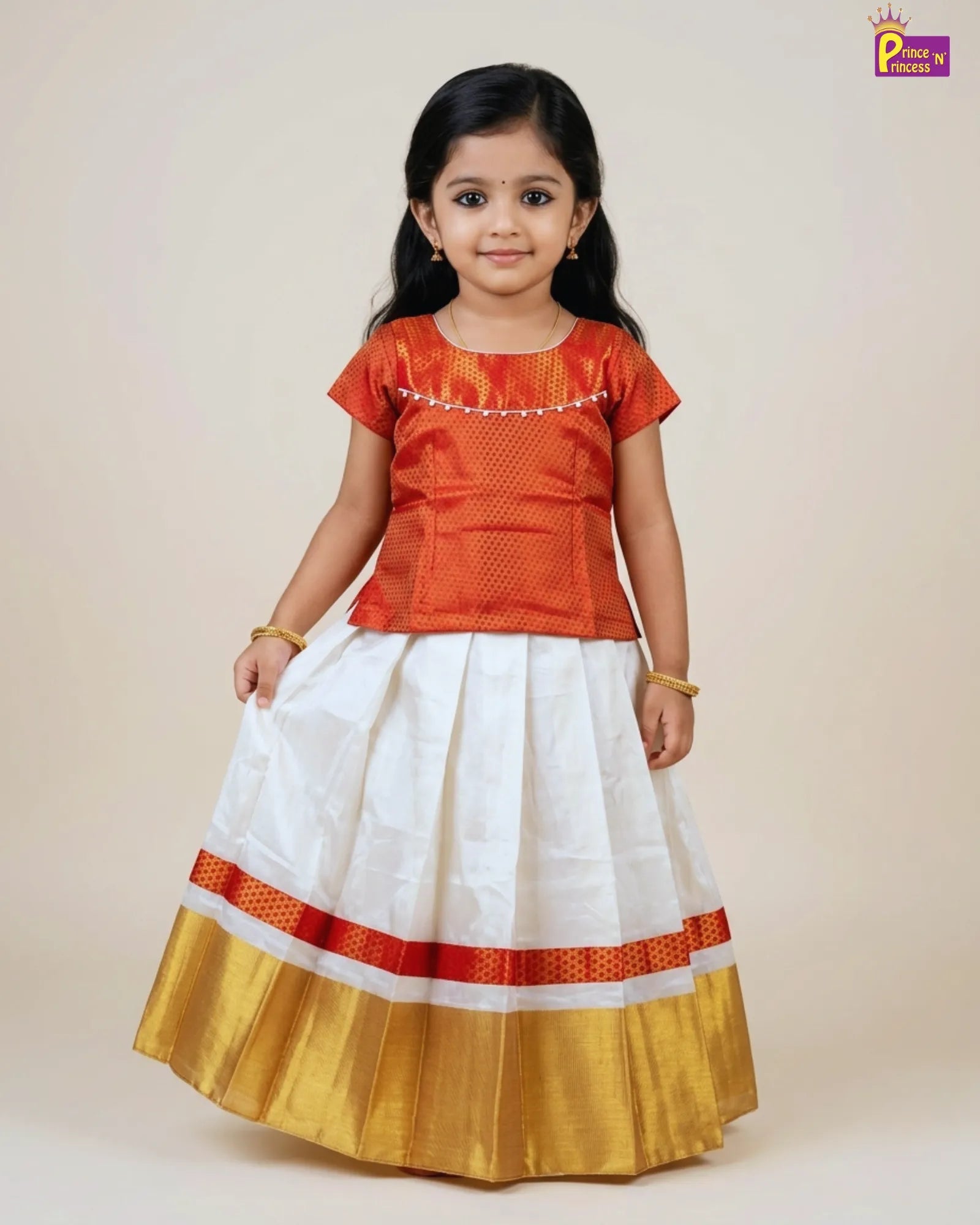 Young girl wearing a traditional outfit with an orange top and white skirt with red and gold border on a beige background.