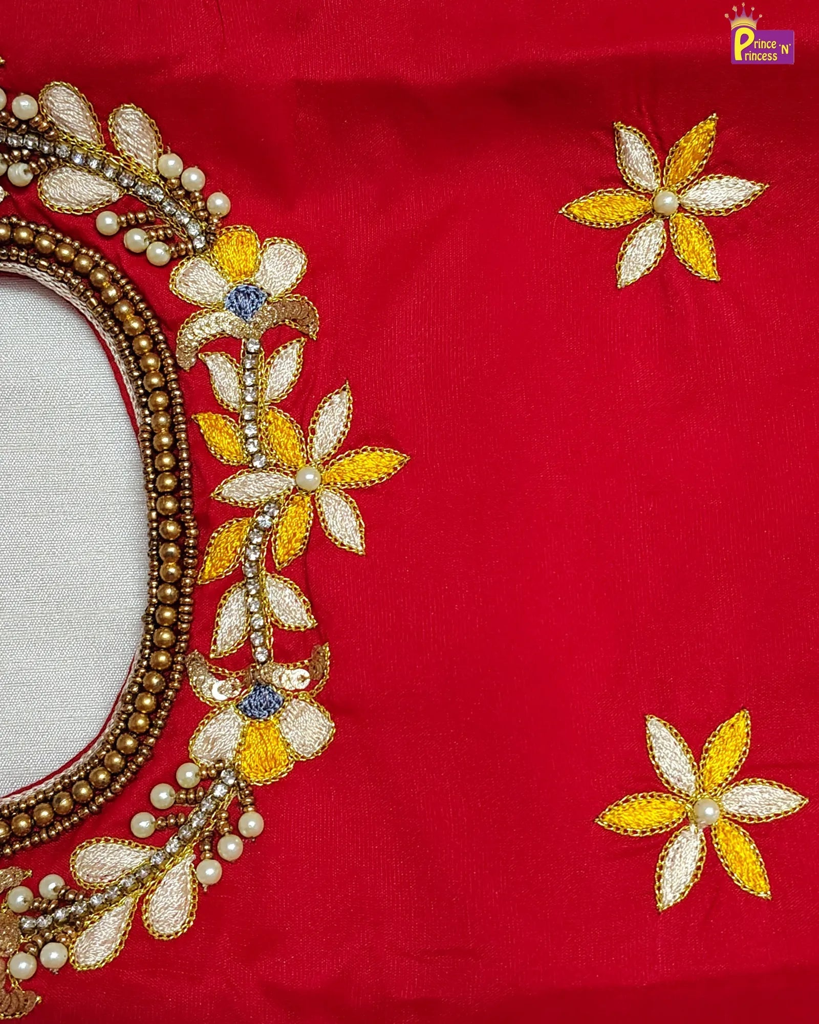 Decorative embroidery on a red fabric with gold and yellow floral patterns.