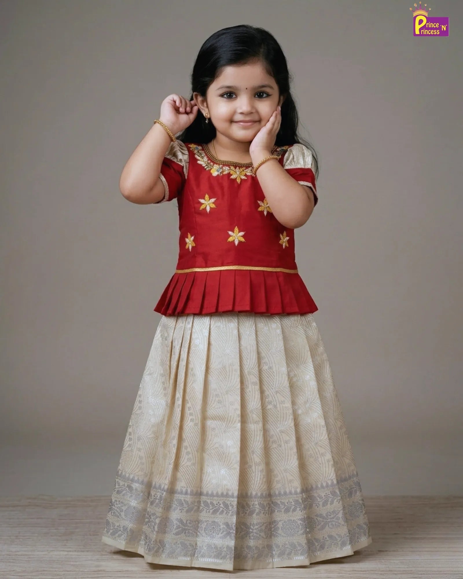 Young girl wearing a red and white traditional outfit with gold details on a plain background