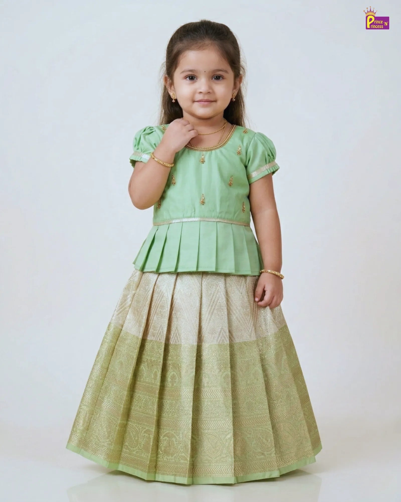 Young girl wearing a green traditional outfit with a white background