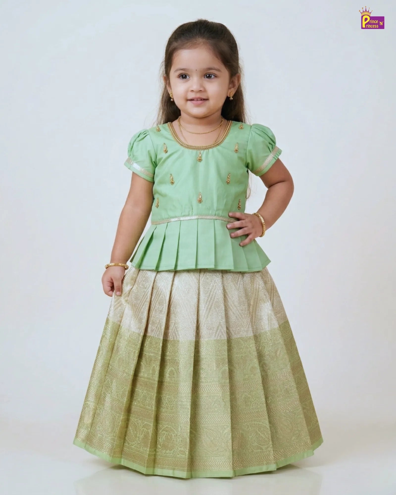 Young girl wearing a green traditional outfit with a white background