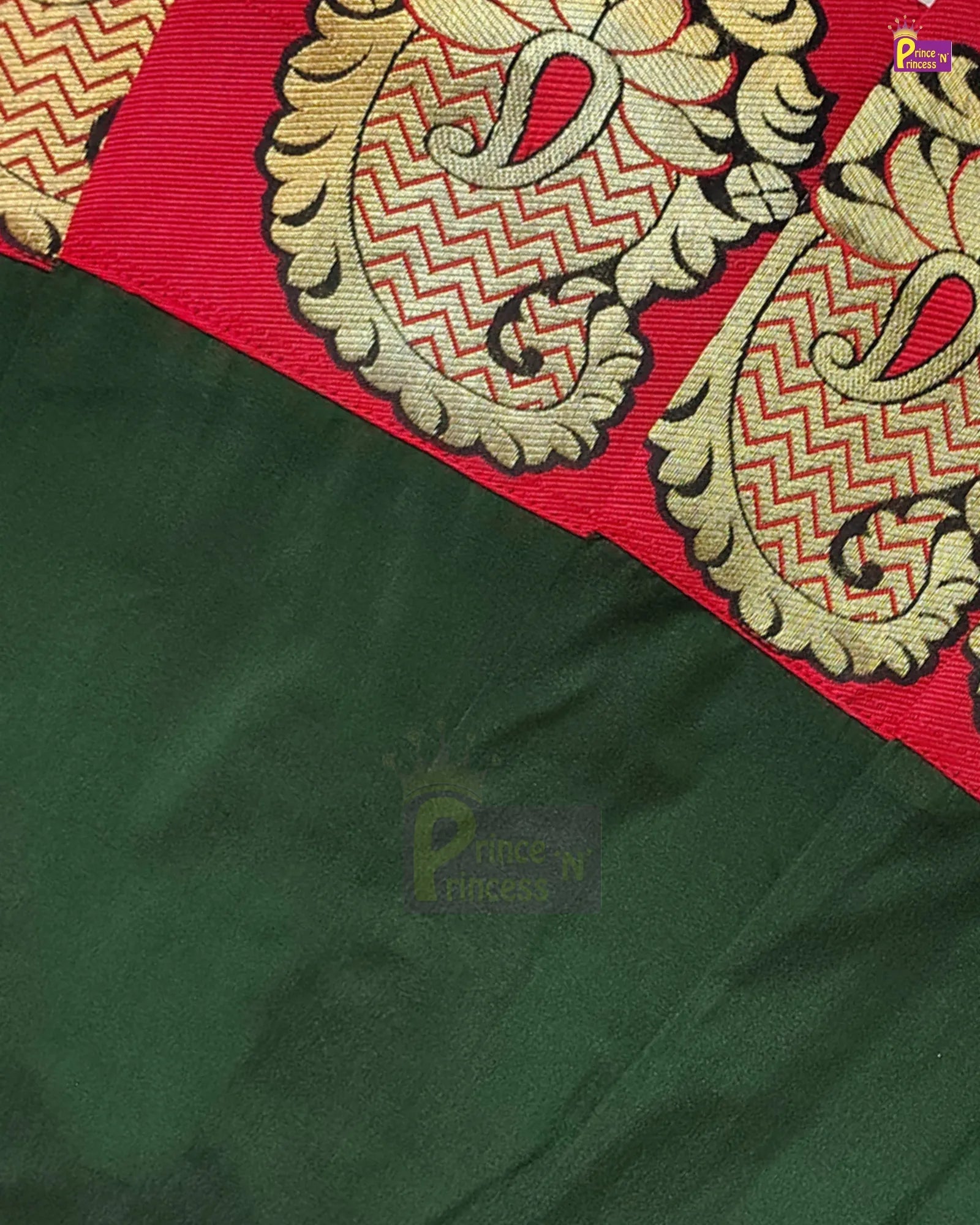 Close-up of a dark green fabric with a red border featuring ornate gold and beige paisley and chevron woven embroidery.