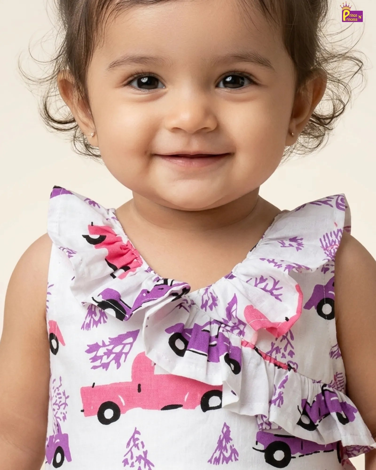 Child wearing a sleeveless top with pink and purple truck pattern on a plain background