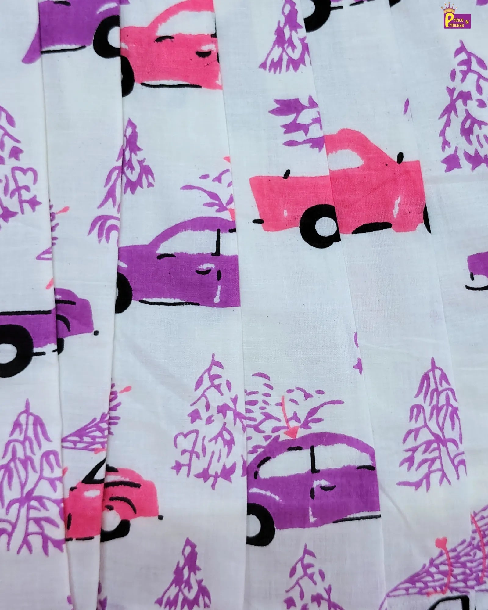 Fabric with pink and purple cars and trees pattern on a light blue background