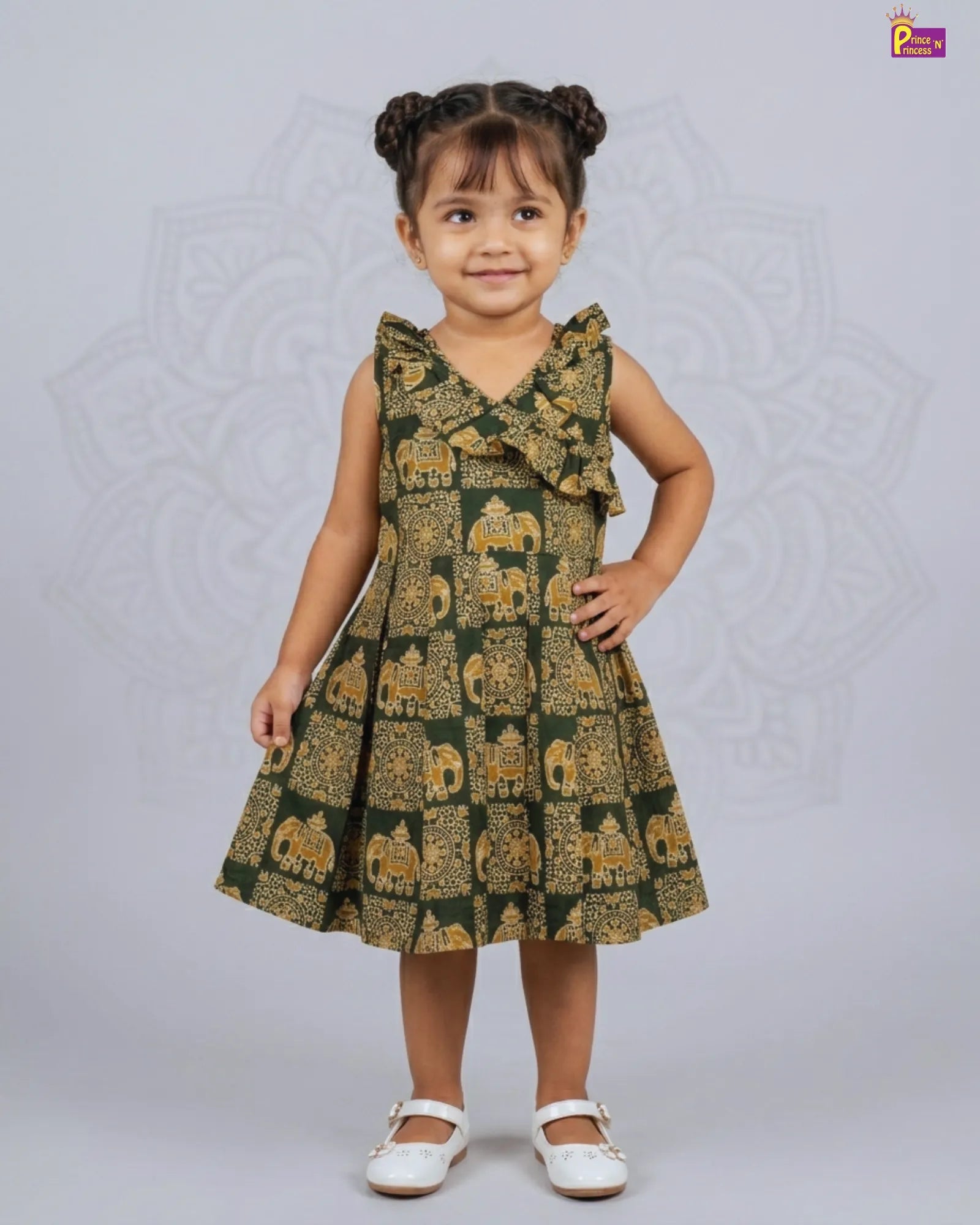 Young girl wearing a green dress with elephant pattern on a light gray background