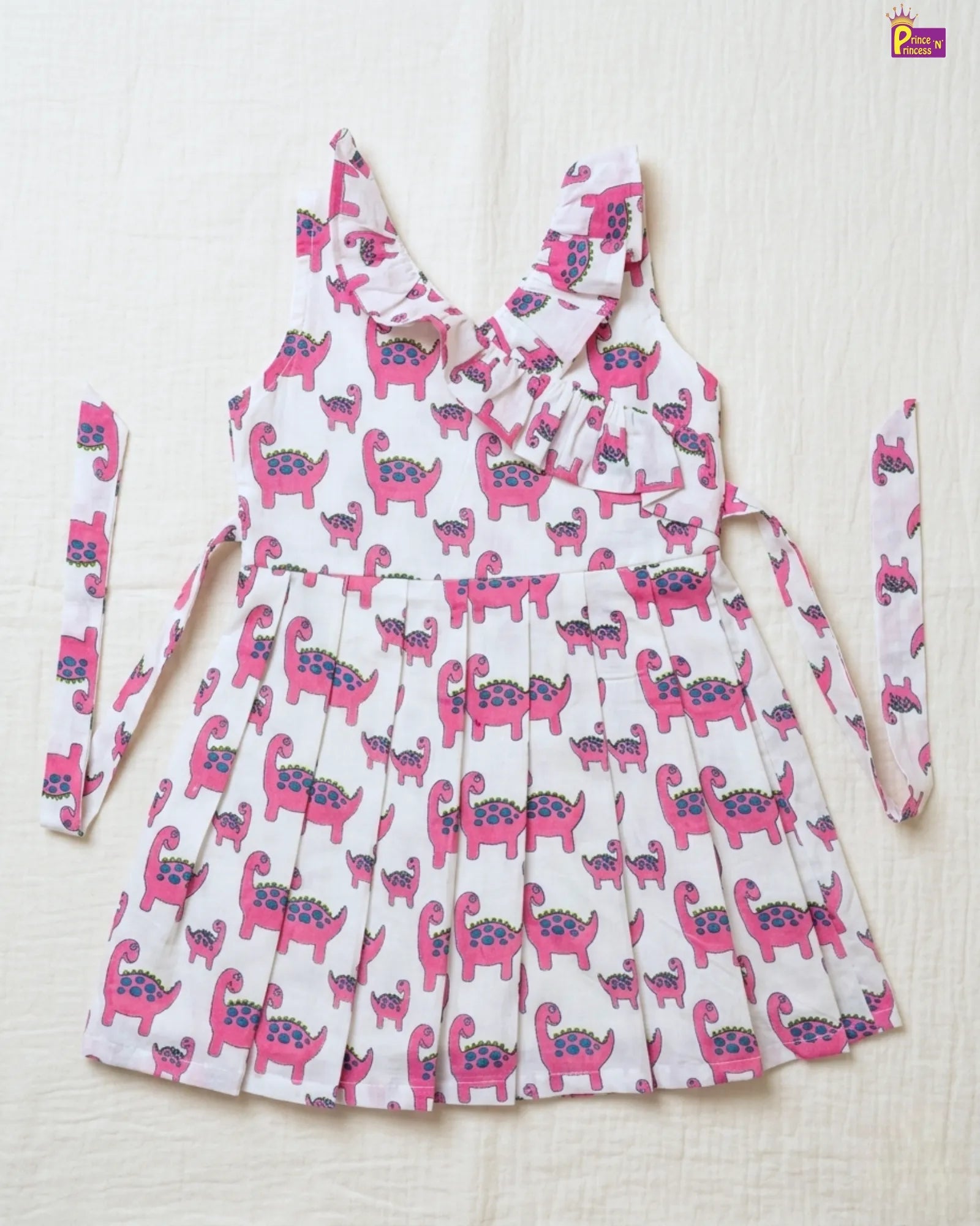 White dress with pink dinosaur pattern on a white background