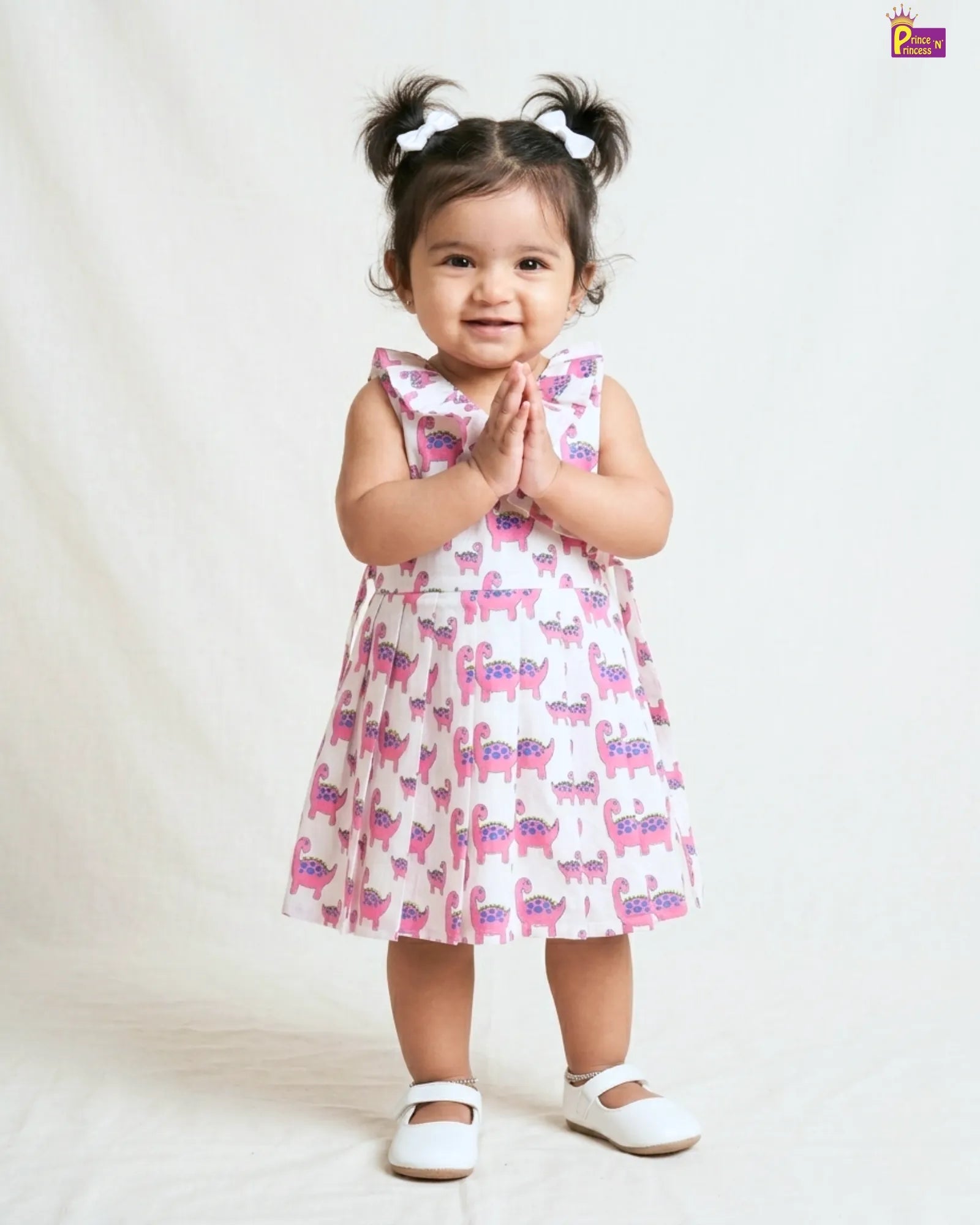 Child wearing a pink dress with animal pattern on a white background