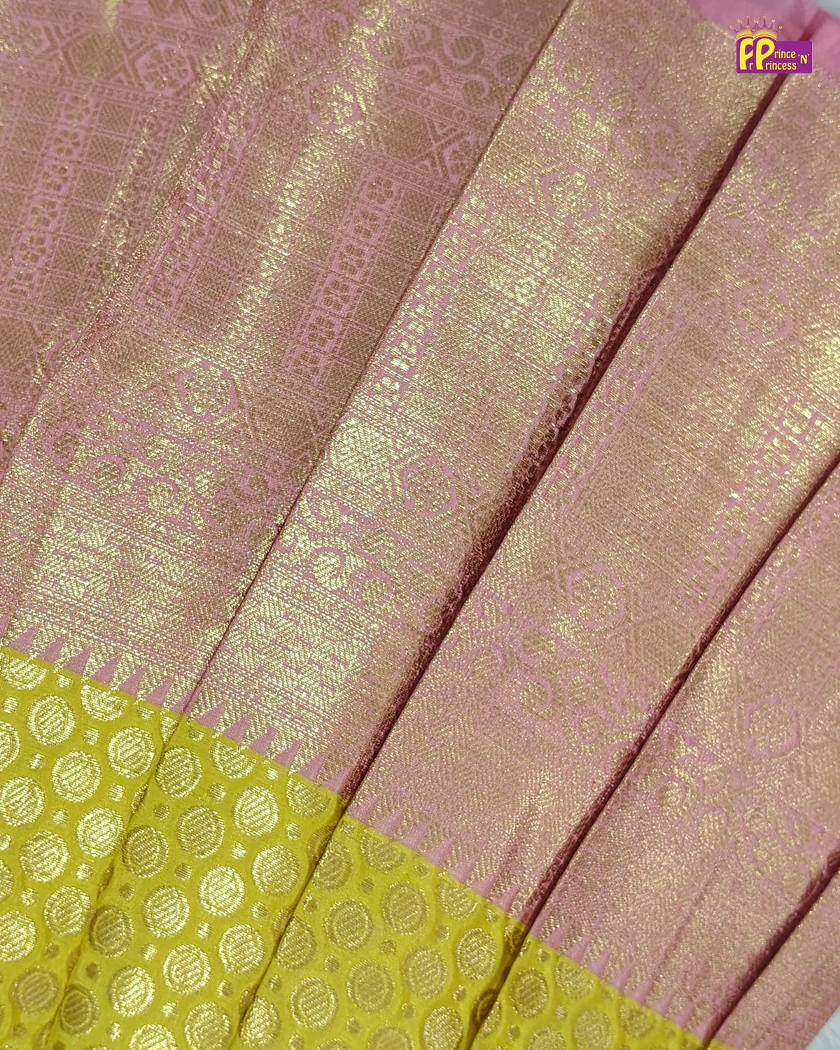 A close-up of a pink and gold woven fabric, likely a saree, showing intricate metallic zari patterns and a contrasting yellow border with circular motifs.