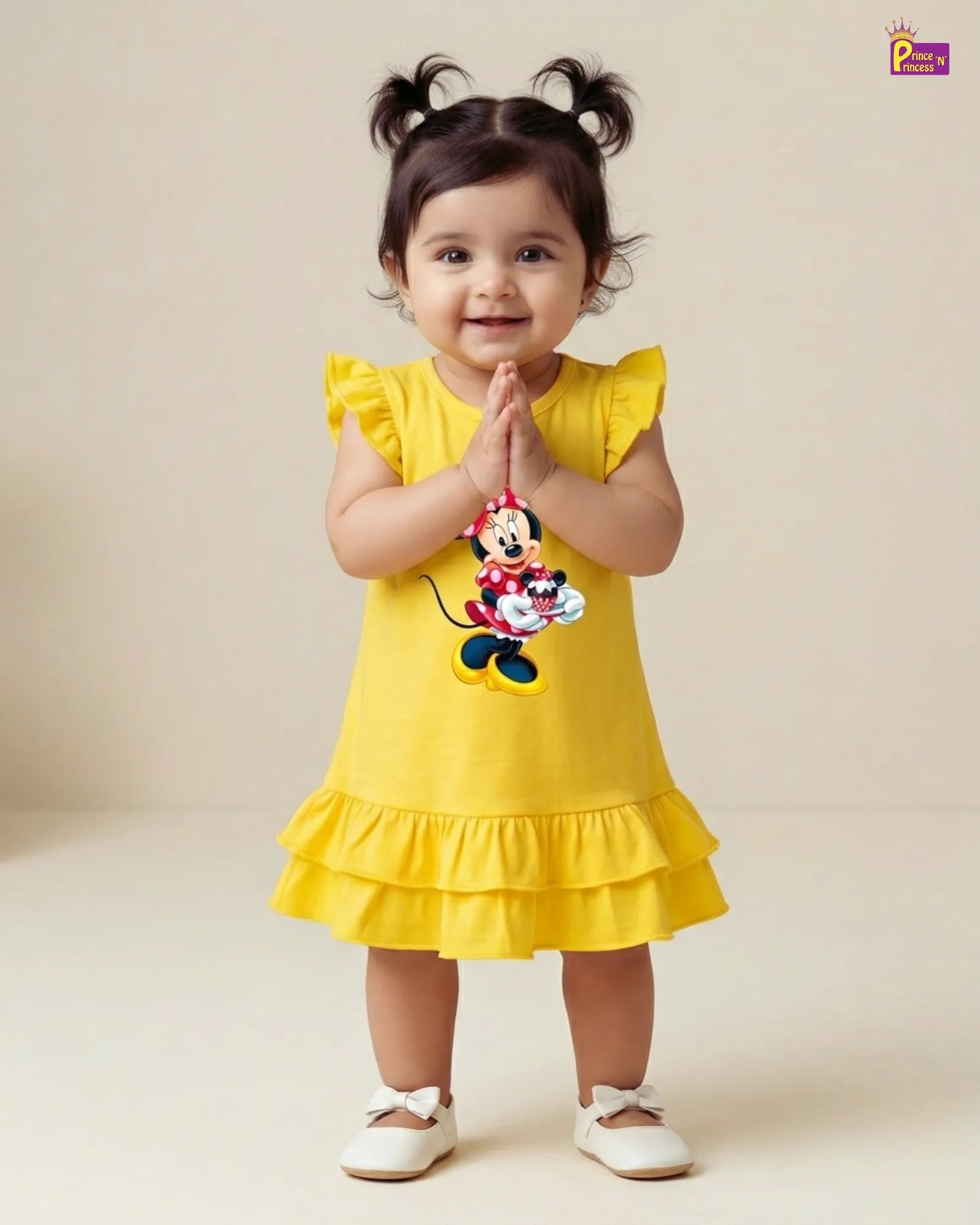 Child wearing a yellow dress with a Minnie Mouse design on a plain background